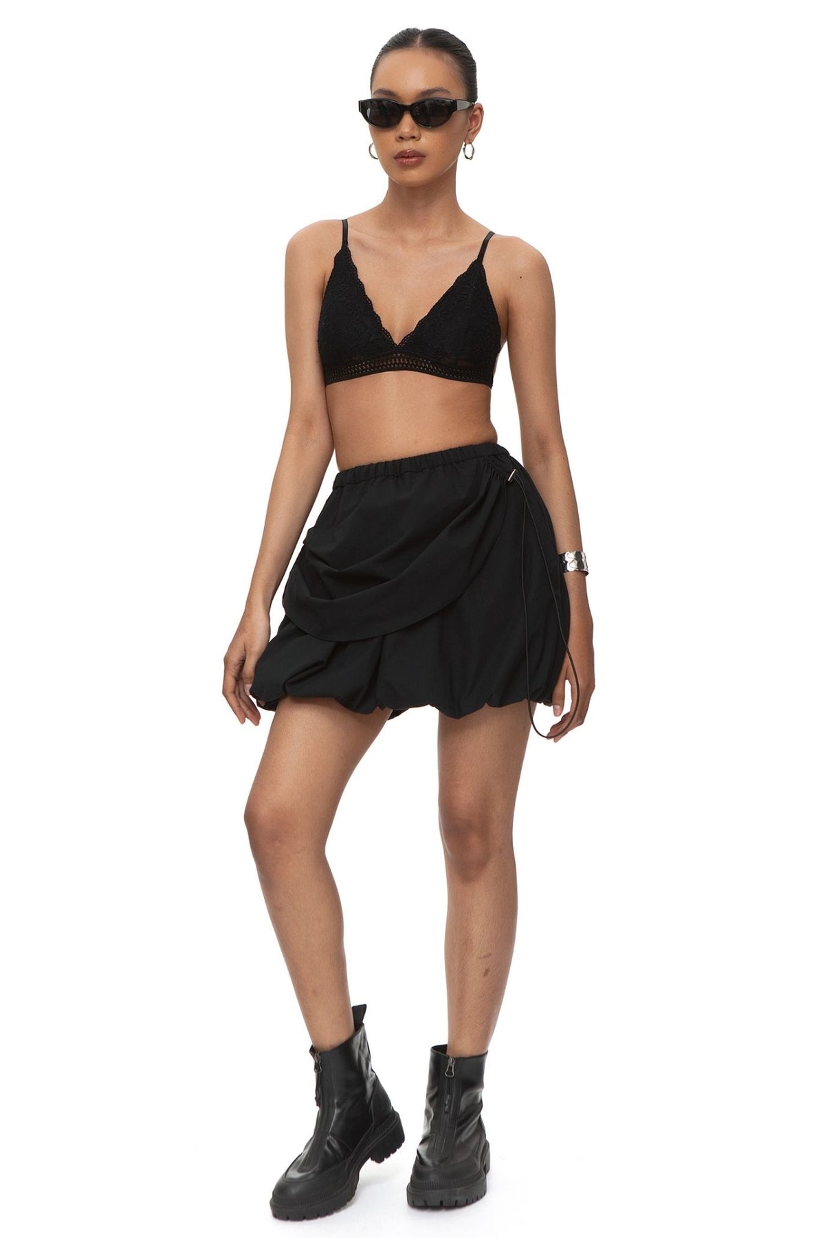 Full front view of black bubble mini skirt with draped side panel.
