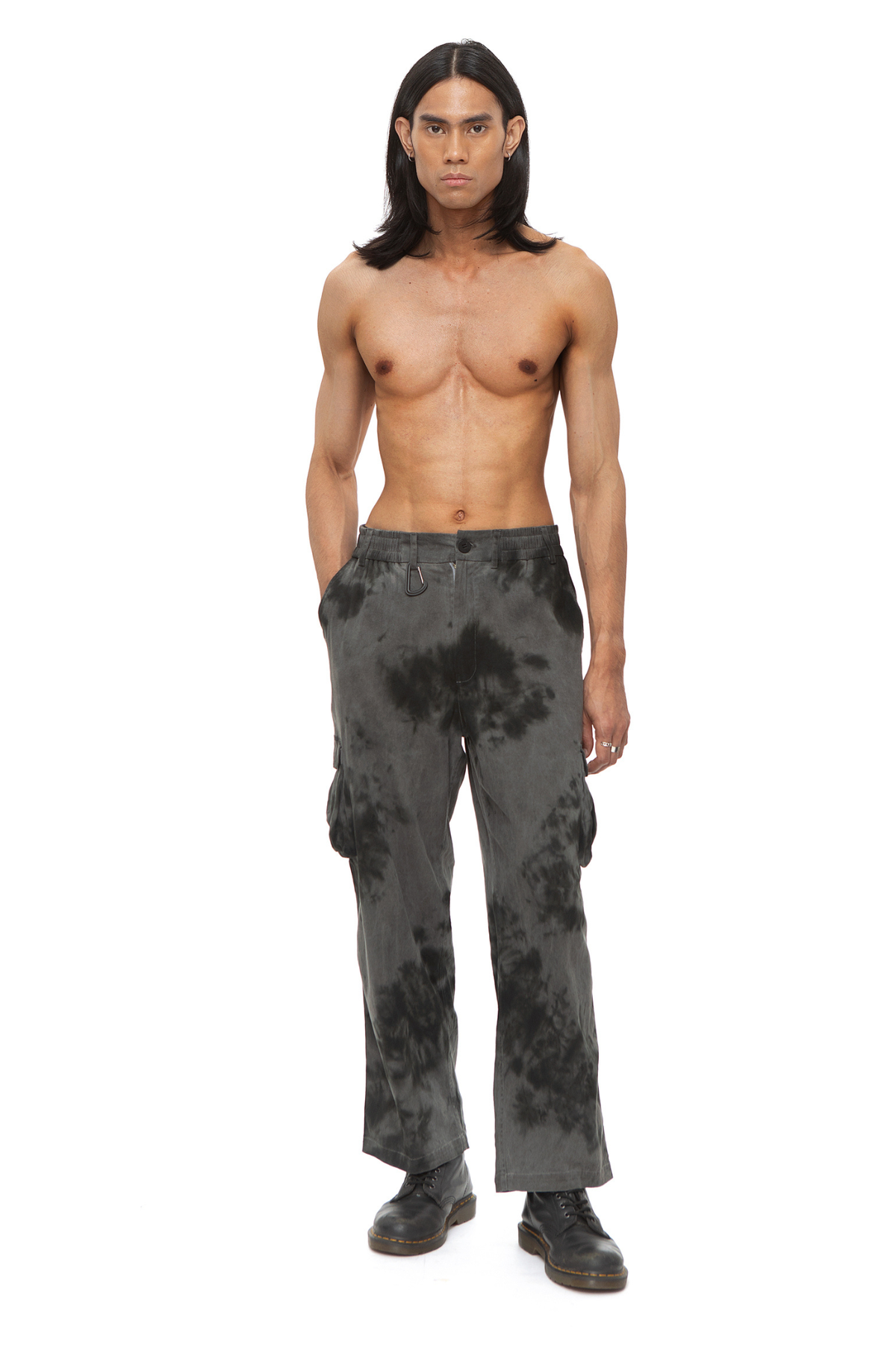 Model wearing grey tie-dye cargo pants with carabiner clip and multi-flap pockets.